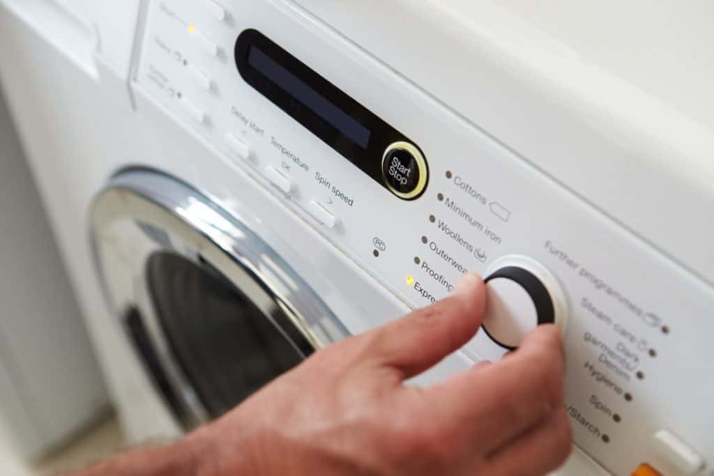 photo of a man configuring the cycle program on a washing machine