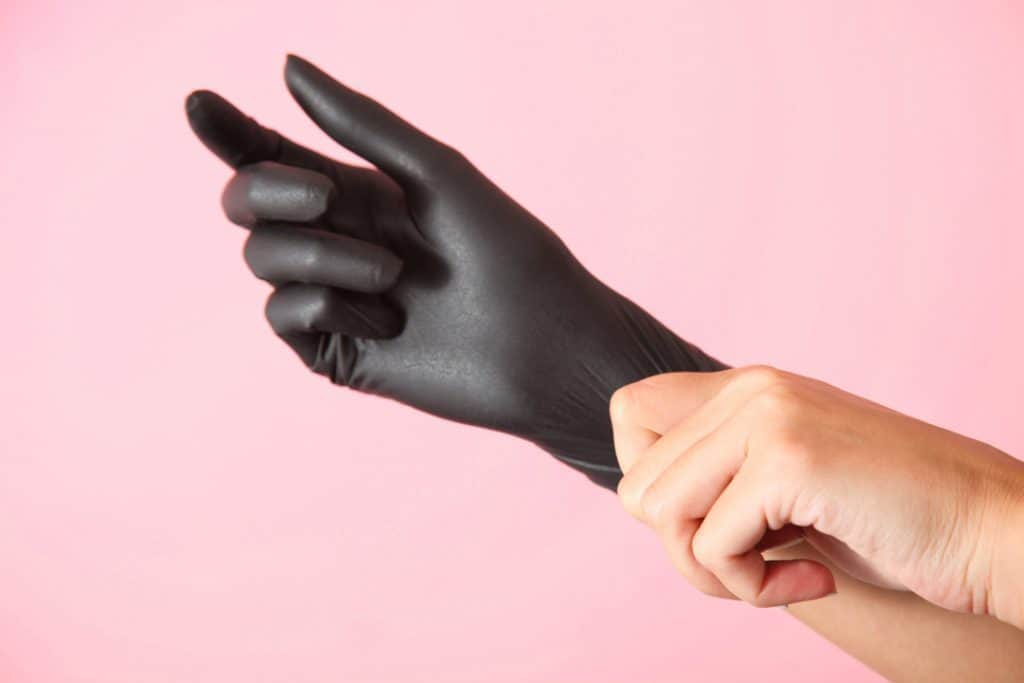 woman wearing black gloves before touching gasoline