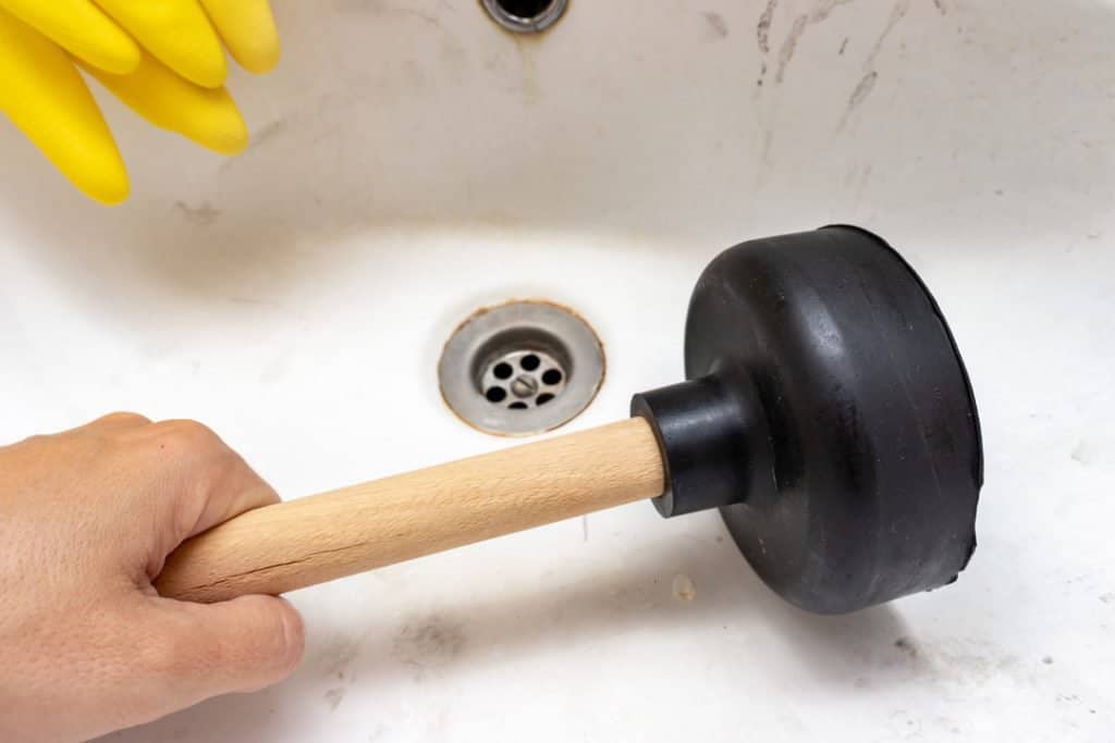 unclog a shower drain with a plunger