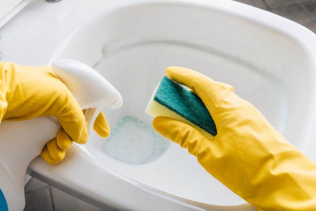 wearing yellow gloves before cleaning toilet seat