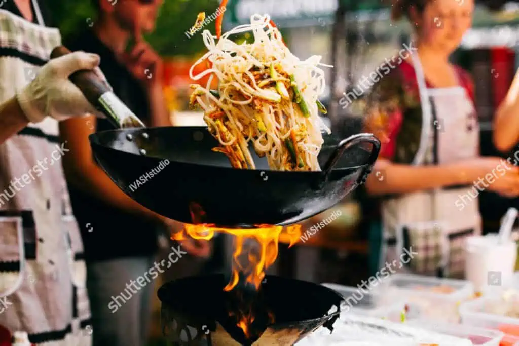 man cooks with a wok