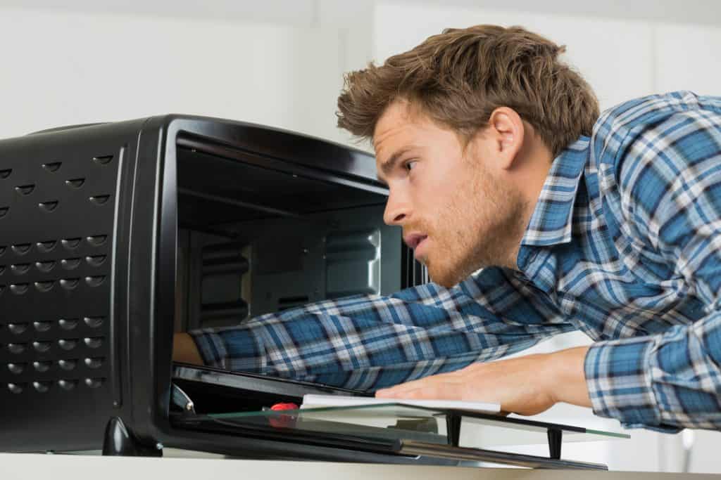 man cleaning toaster oven